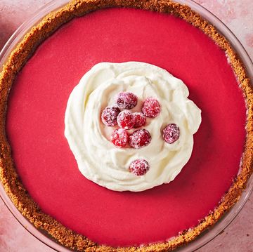 cranberry pie with white frosting and red berries on a red plate