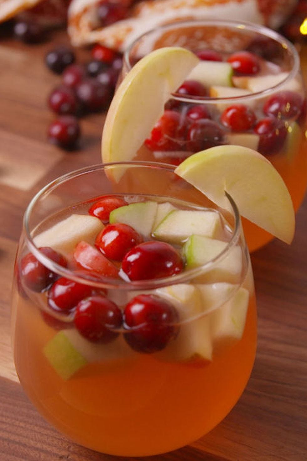 a glass of cranberry sangria with apple chunks