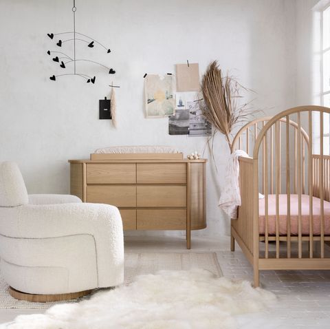 nursery with crib, sherpa chair, and wood dresser