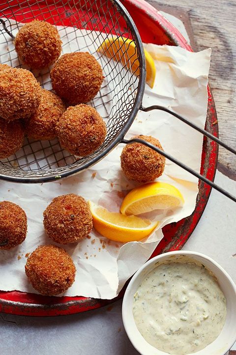 crawfish boudin balls with lemon wedges and dipping sauce on the side