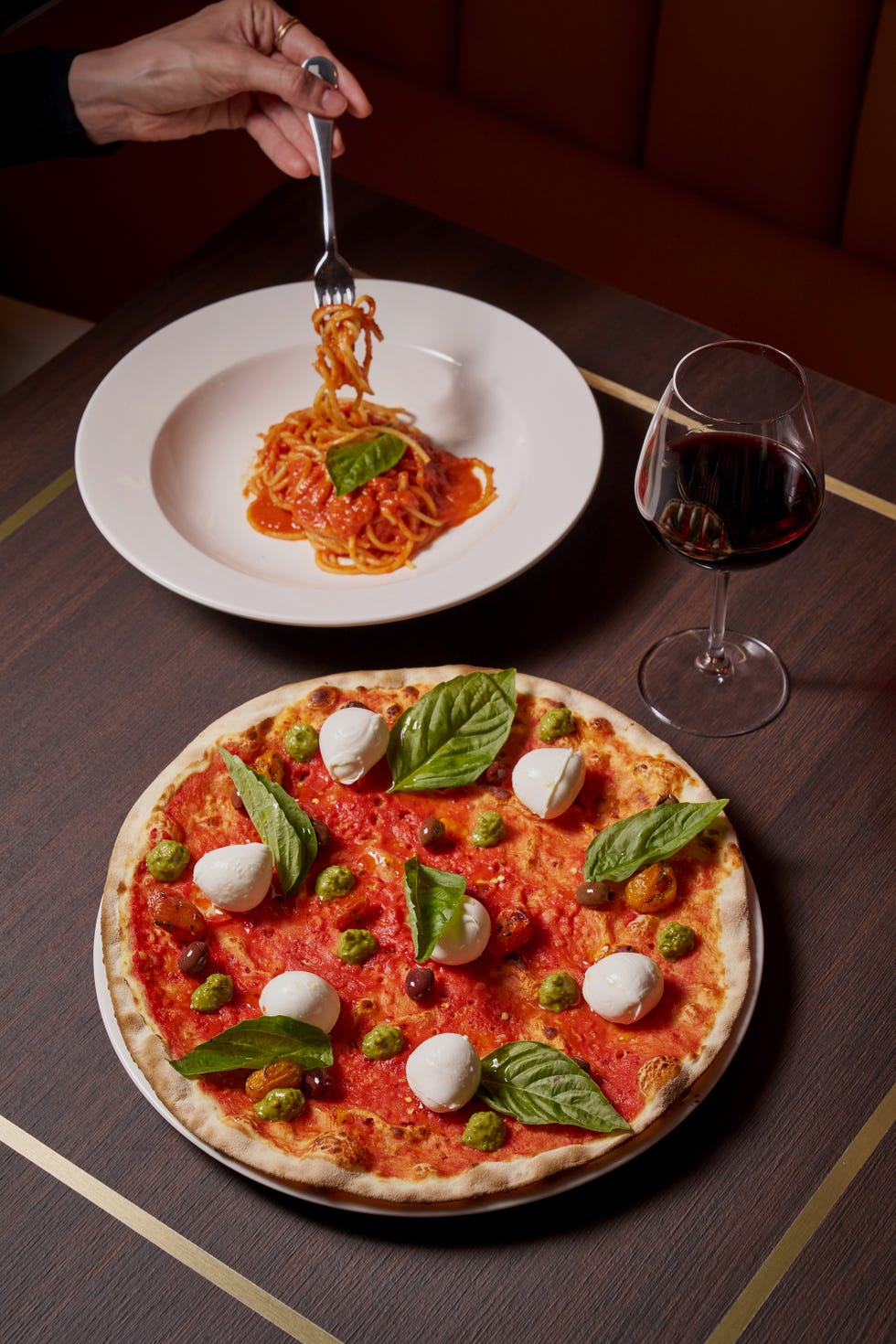 a table setting with pizza pasta and red wine