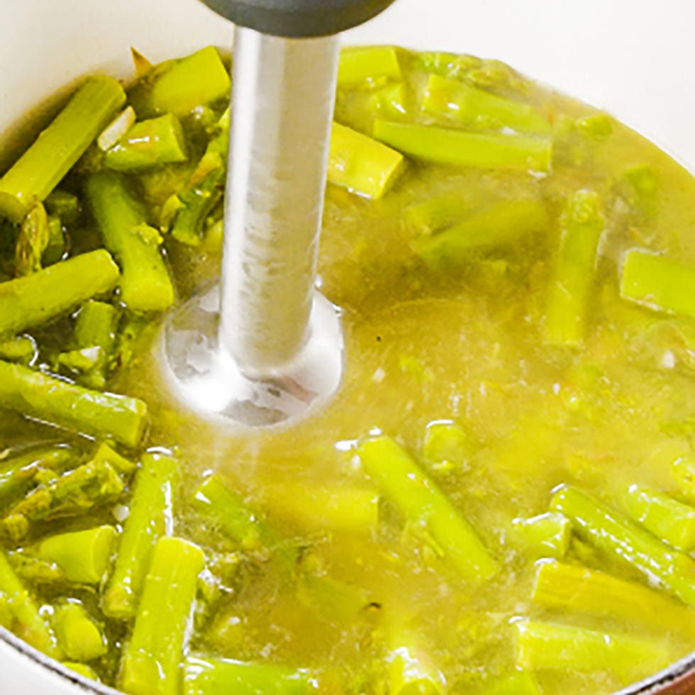 blending asparagus soup in a pot with an immersion blender