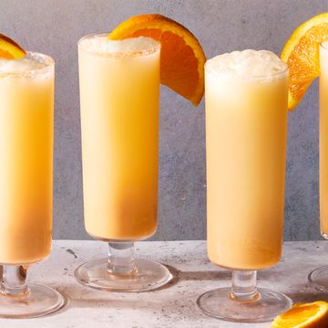 creamsicle mimosas filled with ice and garnished with an orange wedge
