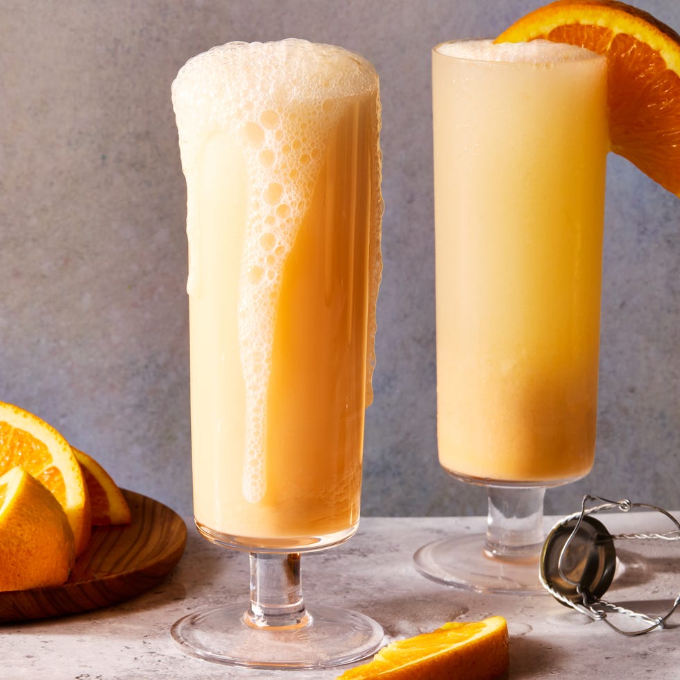 creamsicle mimosas filled with ice and garnished with an orange wedge