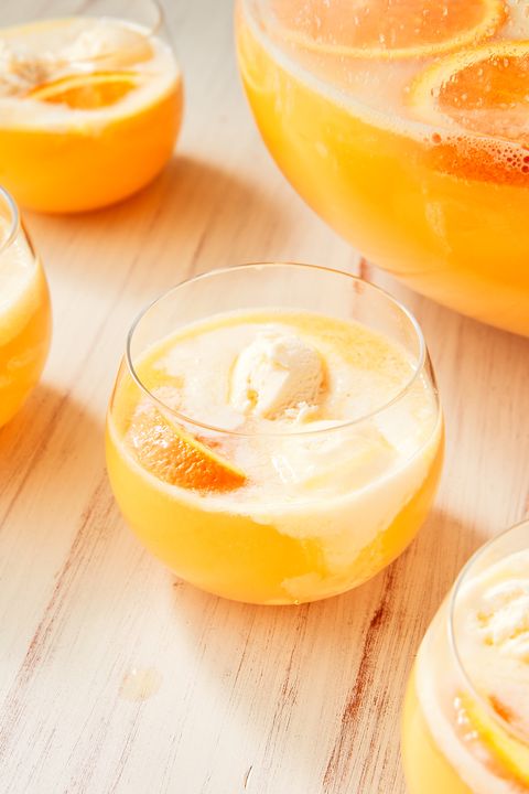 creamsicle punch cocktail with orange juice and vanilla ice cream in a glass with an orange wedge
