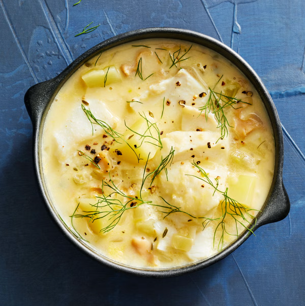 creamy fish and clam chowder in bowl with dill on top