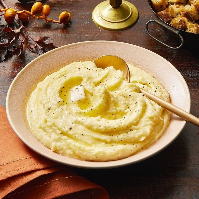 a bowl of thanksgiving mashed potatoes with a serving spoon and pat of butter