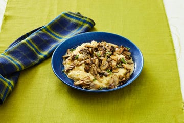 a bowl of creamy polenta topped with mushrooms and herbs