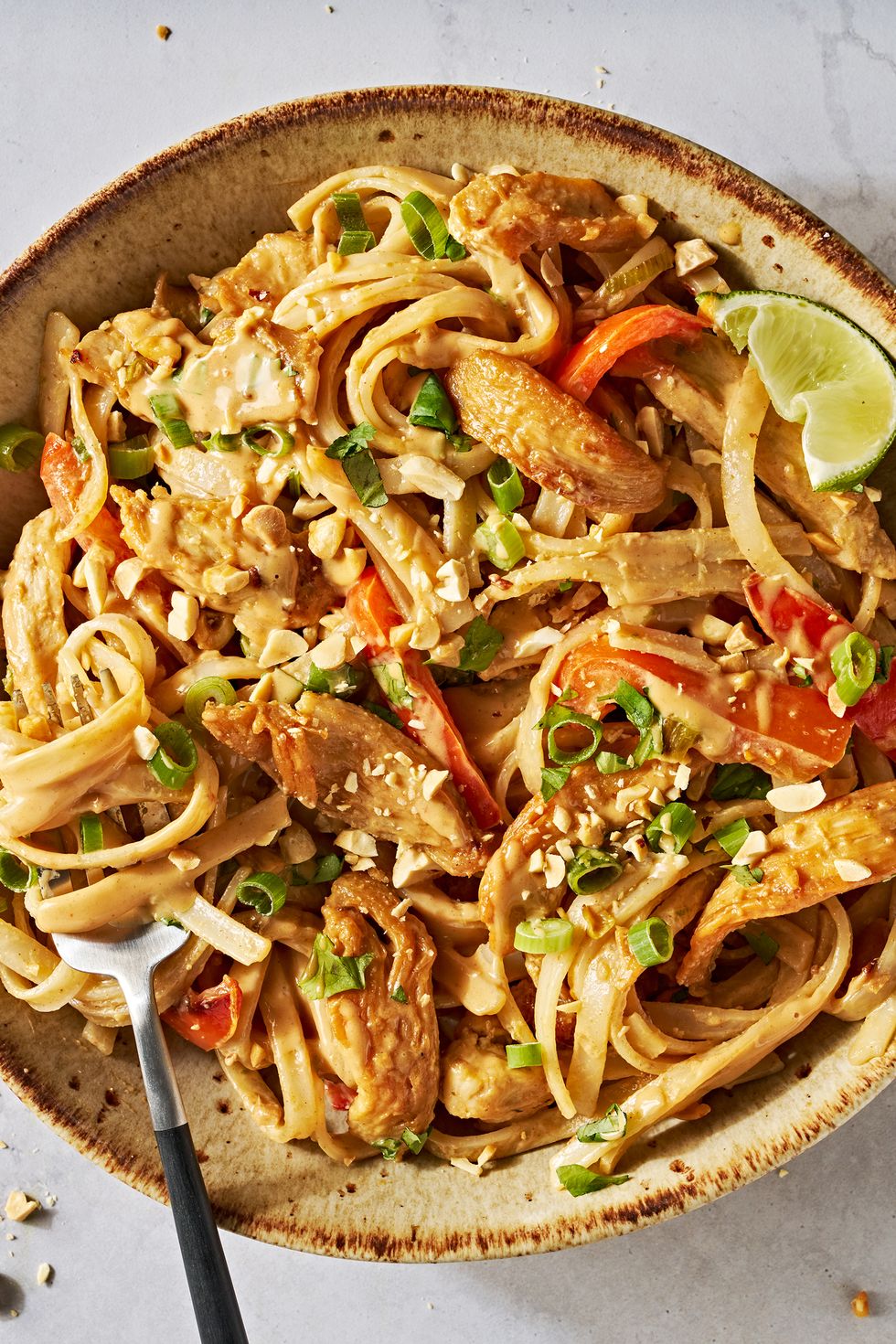 chicken with noodles and carrots in a creamy peanut lime sauce topped with peanuts