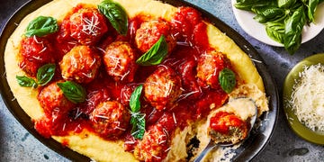 creamy polenta topped with meatballs in a red sauce
