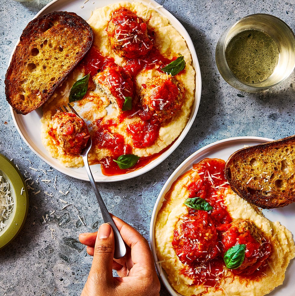 creamy polenta topped with meatballs in a red sauce