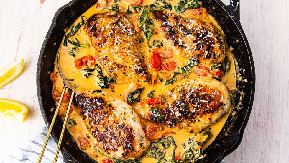 chicken breasts in a creamy tuscan sauce in a cast iron skillet