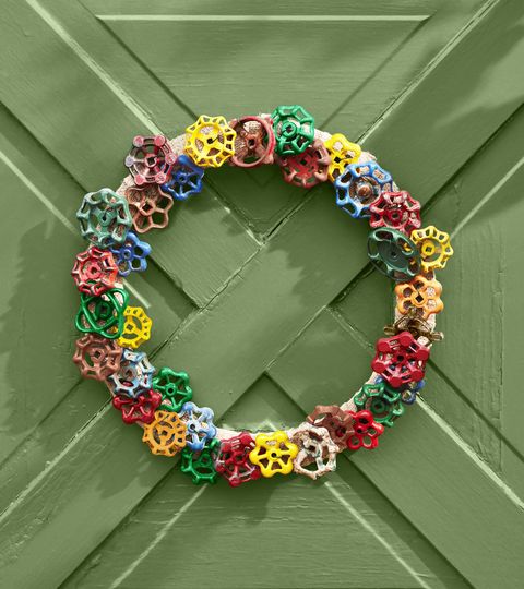 wreath made from vintage faucet handles hung on a green door