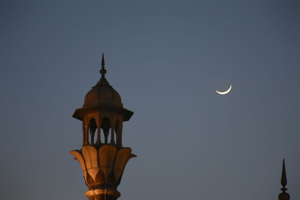 een foto van een minaret naast de maan