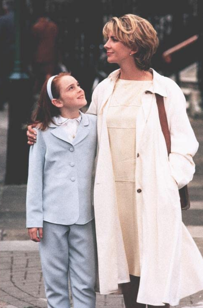 a woman and a child standing together showcasing their outfits
