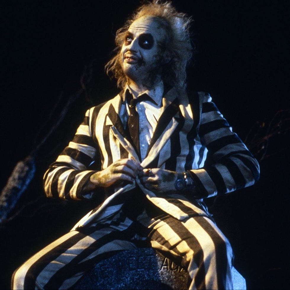 Character in a striped suit seated on a gravestone Character in a striped suit seated on a gravestone