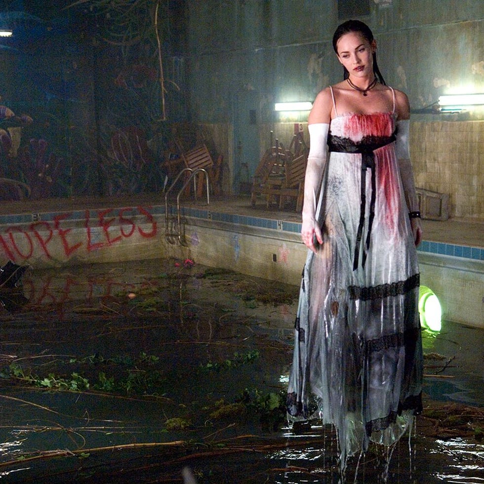 A figure standing in a pool filled with water and vegetation A figure standing in a pool filled with water and vegetation