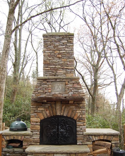 diy stone outdoor fireplace with masonry chimney and hearth, with oven on one side and firewood storage on the other