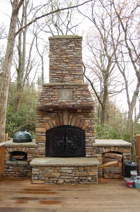 diy stone outdoor fireplace with masonry chimney and hearth, with oven on one side and firewood storage on the other