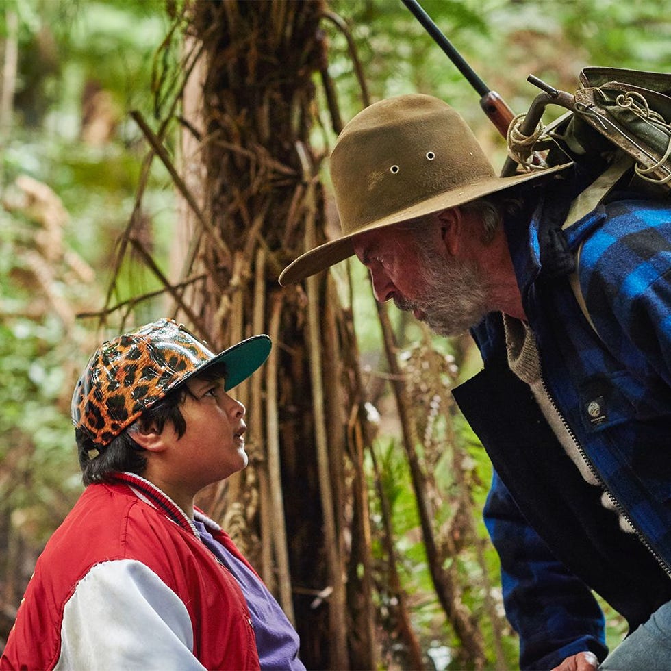 two individuals engaged in conversation in a forested area
