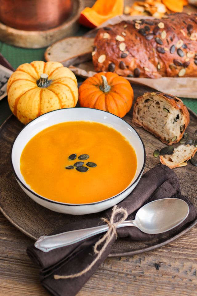autumn pumpkin soup food styling photography with rustic chic wood and flowers in the kitchen