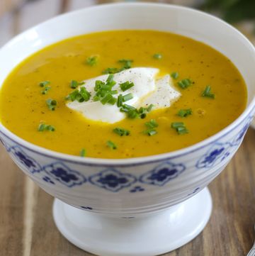 a bowl of vegetable soup with creme fraiche and chives