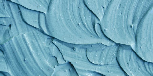 Blue cambrian cosmetic clay (facial mask, cream) texture close up, selective focus. Abstract background with brush strokes.