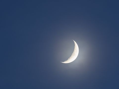Crescent moon against clear sky at night.