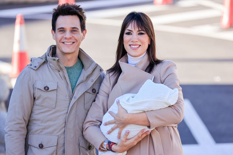 a man and woman holding a baby