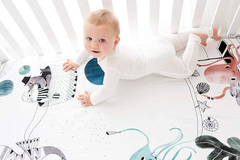 baby lying down on stomach on an animal print rookie humans crib sheet crib safety tips
