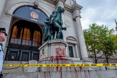 crime scene tape around the roosevelt statue covered in "