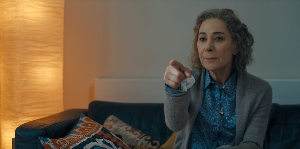 an individual sitting on a couch gesturing emphatically