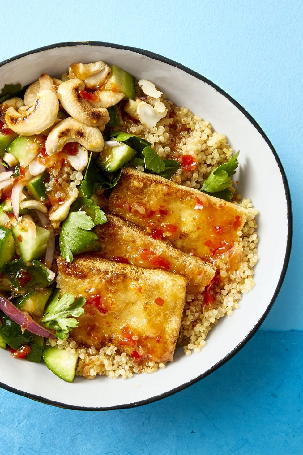 crispy tofu over couscous with a side salad made of cashew, cilantro, red onion, and cucumber