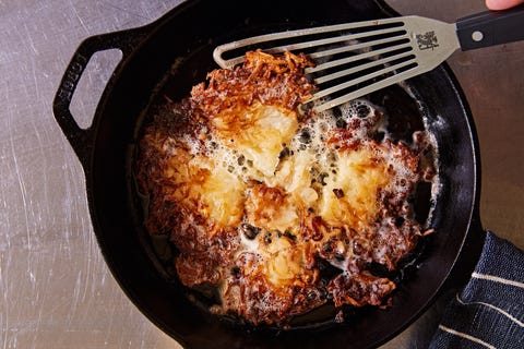 crispy hash browns with a spatula in a black cast iron pan