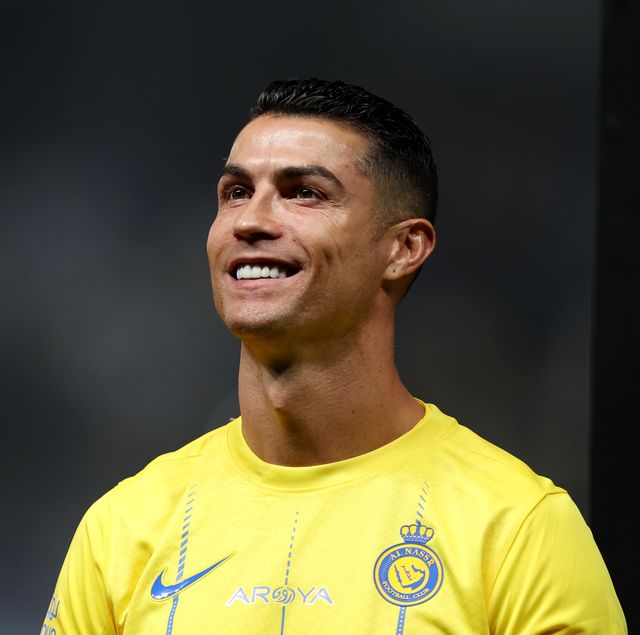 al nassr soccer player cristiano ronaldo looking up and smiling before a match