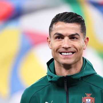 a man in a green zipup sweatshirt smiles