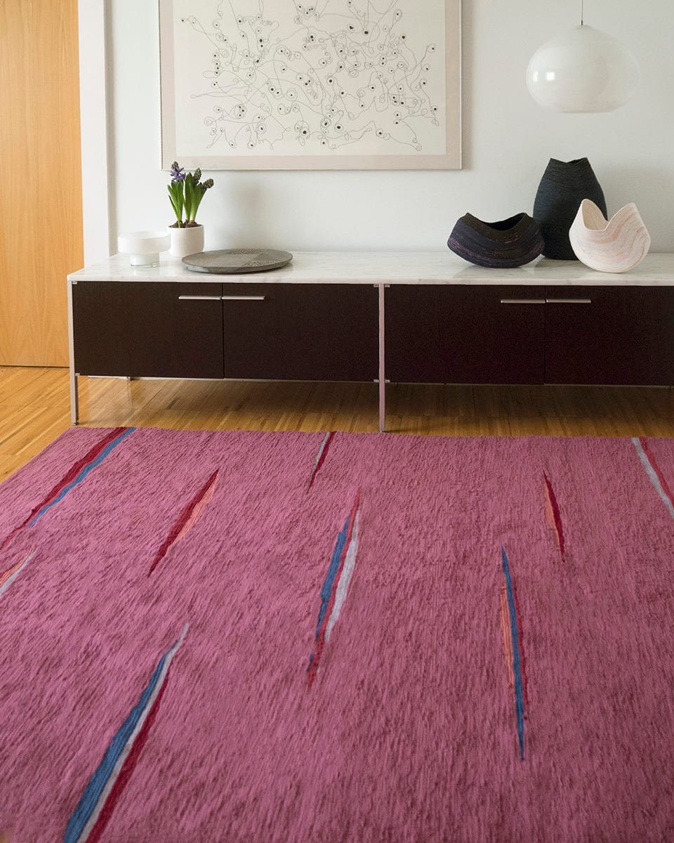 alfombra rosa de cristina vallejo y aparador en madera oscura