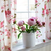 Crock of pretty pink peonies on windowsill in kitchen crock of pretty pink peonies on windowsill in kitchen