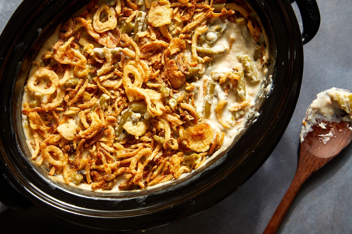 green bean casserole topped with crunchy fried onions in a crockpot insert