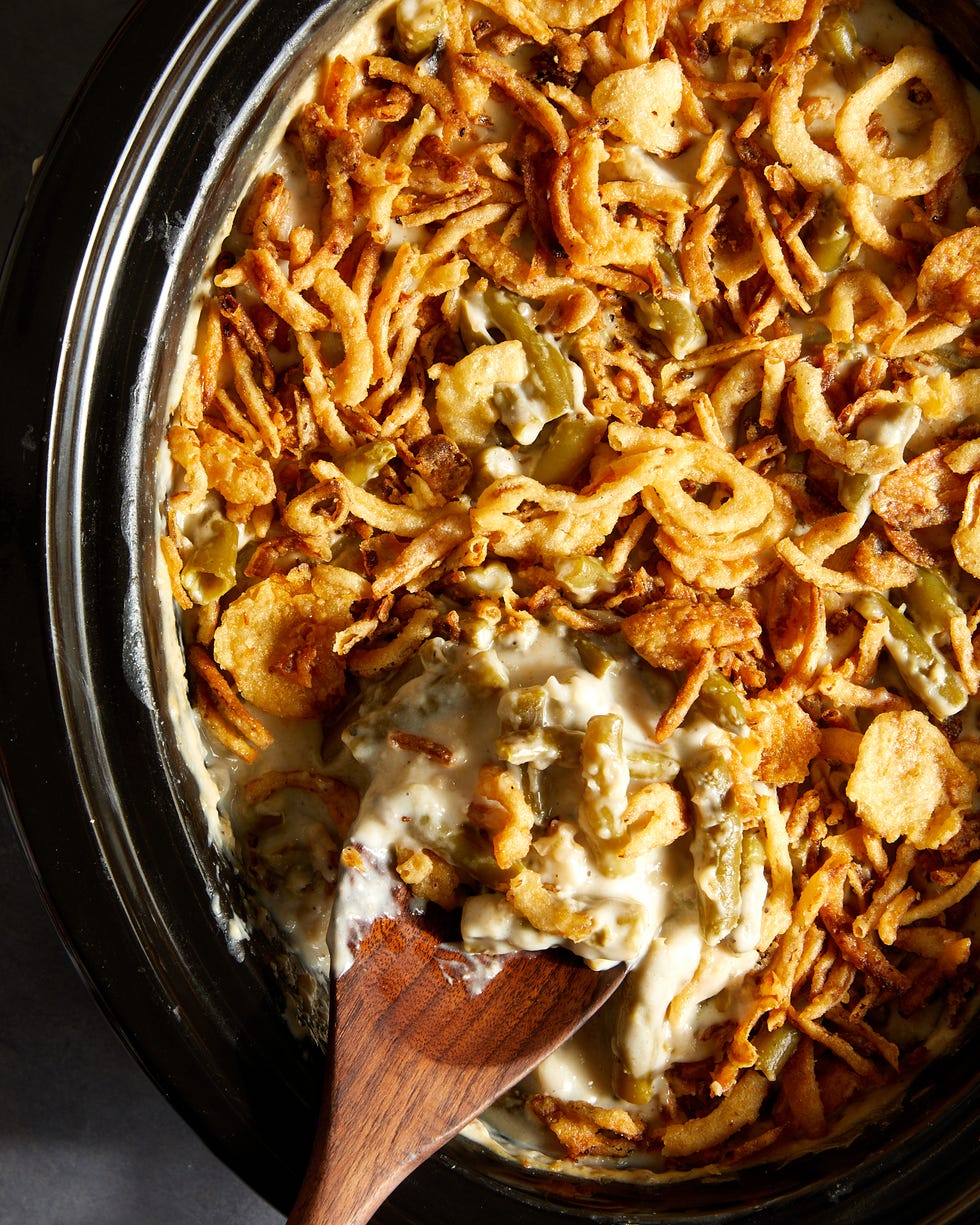green bean casserole topped with crunchy fried onions in a crockpot insert