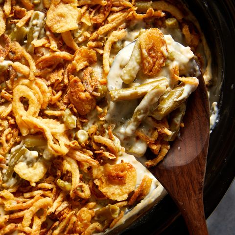 green bean casserole topped with crunchy fried onions in a crockpot insert