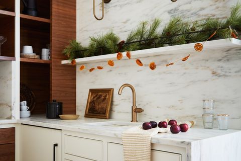 a white kitchen with a few fruits and other autumnal accents