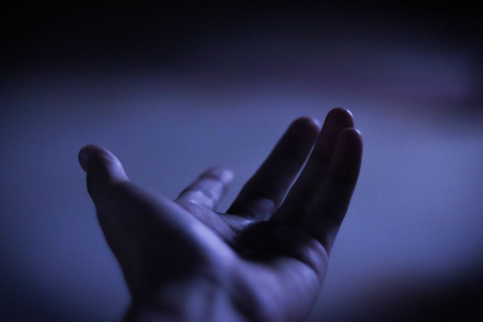 Cropped Hand Gesturing In Darkroom
