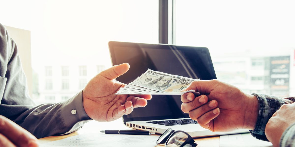 cropped hand giving money to businessman in office royalty free image
