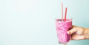 Cropped Hand Holding Drink Against Wall