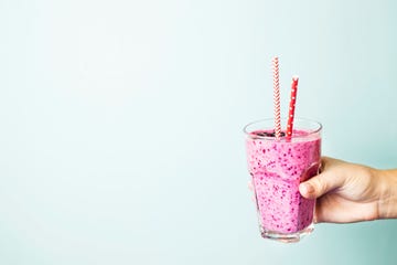 Cropped Hand Holding Drink Against Wall