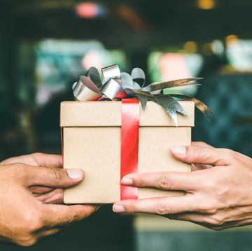 cropped hand of man giving christmas present to female friend