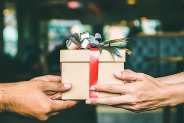 cropped hand of man giving christmas present to female friend