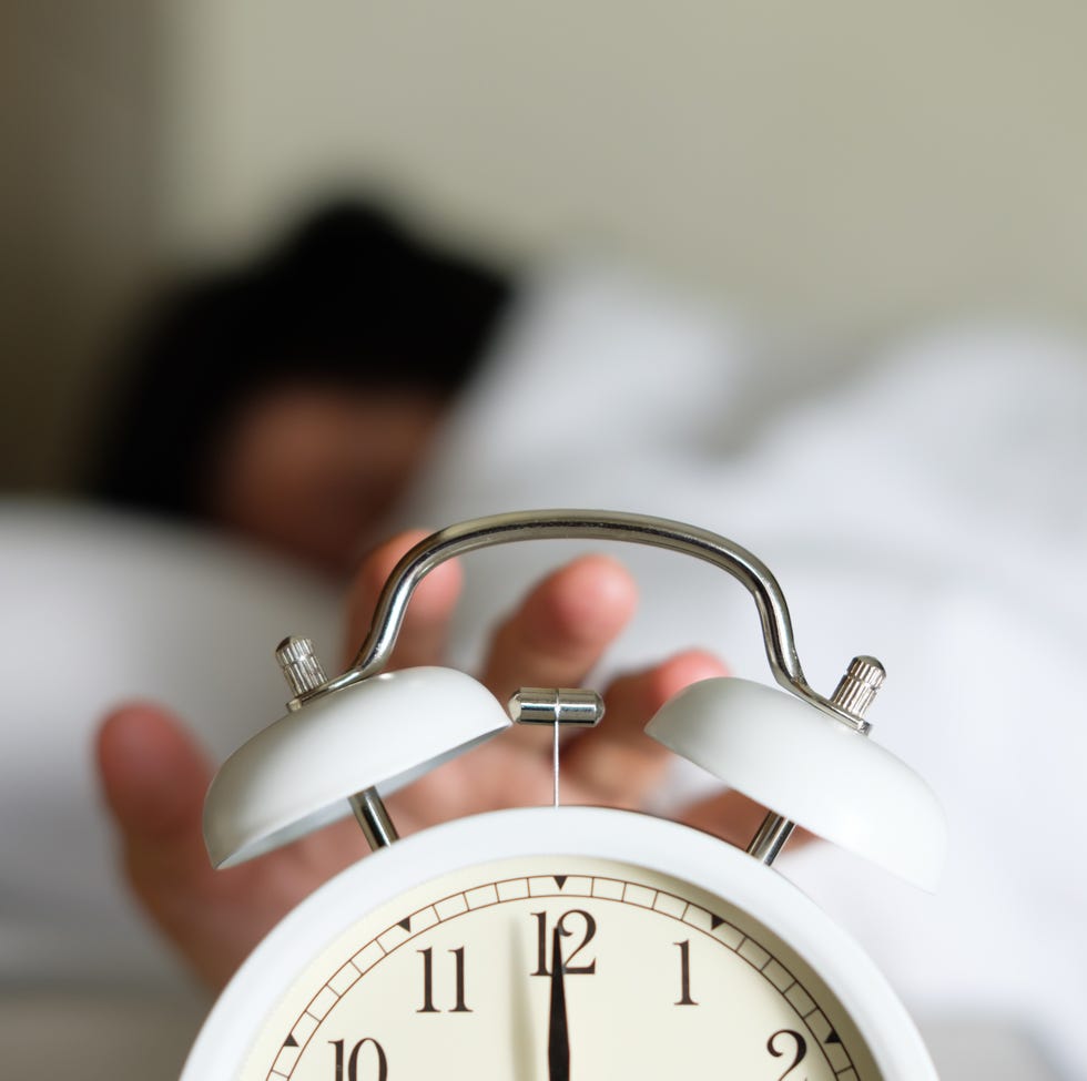 Cropped Hand Of Person Turning Off Alarm Clock