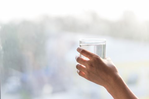 Cropped Hand Of Woman Holding Water In Glass